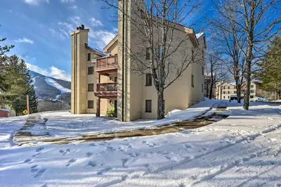 a building in the snow with snow covered ground at Steps to Ski Shuttle! Snow Mountain Village Condo in Dover