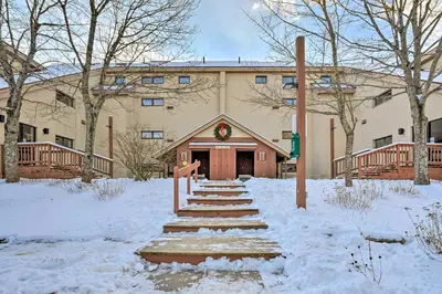 a building with snow in front of it at Steps to Ski Shuttle! Snow Mountain Village Condo in Dover
