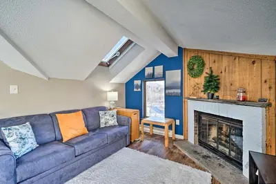 a living room with a couch and a fireplace at Steps to Ski Shuttle! Snow Mountain Village Condo in Dover
