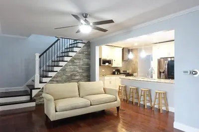 a living room with a couch and a staircase at Best Home To Visit NYC+Hot Tub+EWR Airport+Free Parking in Hillside