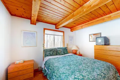 a bedroom with a bed and a tv in it at Snow Country Home in Wilmington