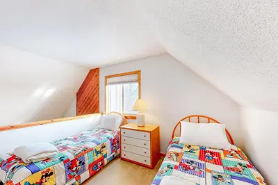 a bedroom with two beds and a mirror at Snow Country Home in Wilmington
