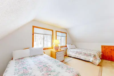 two beds in a room with two windows at Snow Country Home in Wilmington