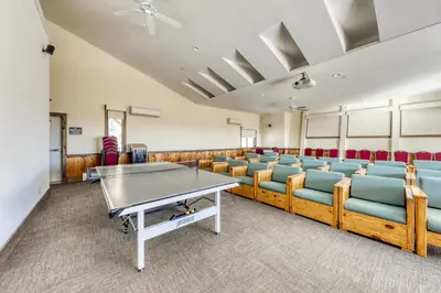 a room with a ping pong table and chairs at Snow Country Home in Wilmington
