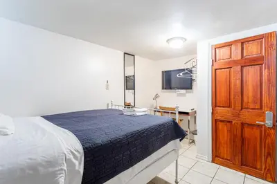 a bedroom with a bed and a wooden door at Best Room To Visit NYC-Subway Access in Newark