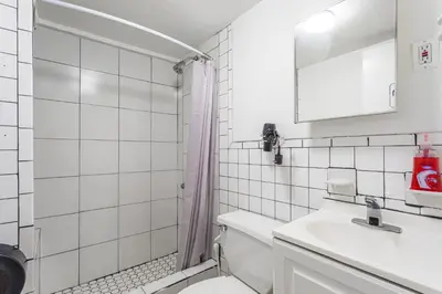 a white bathroom with a toilet and a sink at Best Room To Visit NYC-Subway Access in Newark