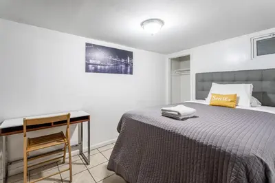 a bedroom with a bed and a desk in it at Best Room To Visit NYC-Subway Access in Newark
