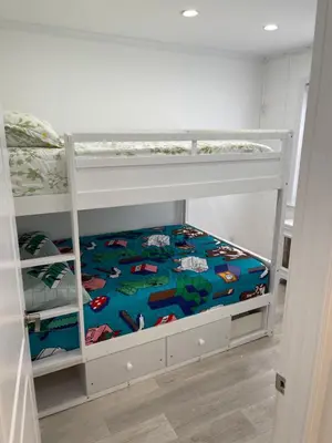 a bedroom with two bunk beds with a superman blanket at Renovated Jacuzzi Tub Home NYC-LGA-JFK Washer-Dryer in Kew Gardens