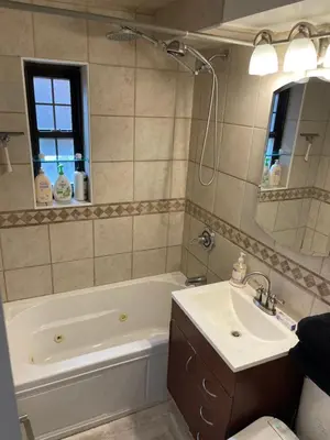 a bathroom with a tub and a sink and a mirror at Renovated Jacuzzi Tub Home NYC-LGA-JFK Washer-Dryer in Kew Gardens