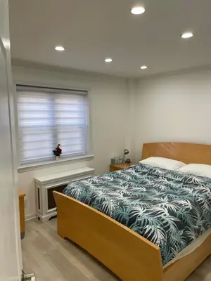 a bedroom with a bed and a window at Renovated Jacuzzi Tub Home NYC-LGA-JFK Washer-Dryer in Kew Gardens