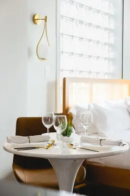 a white table with wine glasses on top of it at The Modernist Hotel in Long Island City