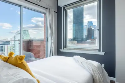 a bedroom with a bed and a large window at The Modernist Hotel in Long Island City