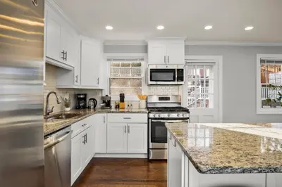 a kitchen with white cabinets and granite counter tops at Waterview house walking distance from Cove Beach-5 mins to downtown-only 40 min to NYC in Stamford