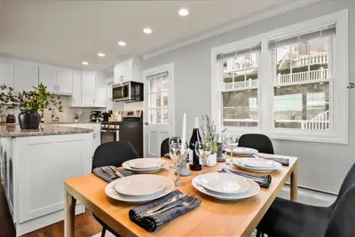 a dining room with a wooden table and chairs at Waterview house walking distance from Cove Beach-5 mins to downtown-only 40 min to NYC in Stamford