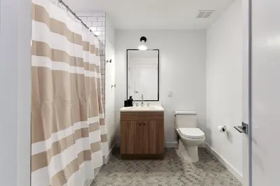 a bathroom with a toilet and a sink and a mirror at Harmony Lofts on Jackson 2 in Hoboken