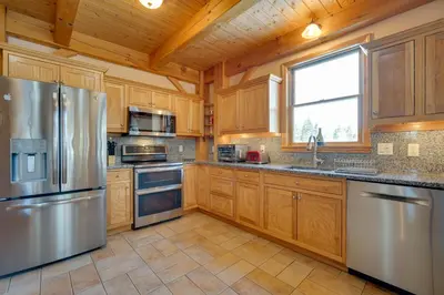 a kitchen with wooden cabinets and stainless steel appliances at Secluded Vermont Retreat Outdoor Pool and Deck in Stratton