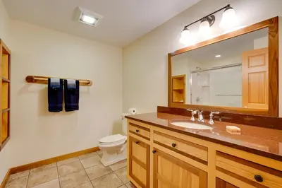 a bathroom with a sink and a toilet and a mirror at Secluded Vermont Retreat Outdoor Pool and Deck in Stratton