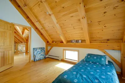 a bedroom with a bed in a room with wooden ceilings at Secluded Vermont Retreat Outdoor Pool and Deck in Stratton