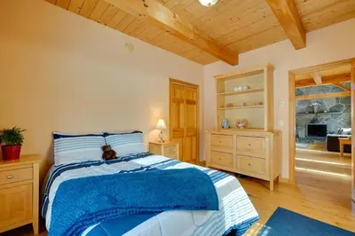 a bedroom with a bed with a blue blanket at Secluded Vermont Retreat Outdoor Pool and Deck in Stratton