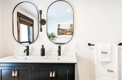 a bathroom with a black vanity and two mirrors at Acorn Lodge - Luxury Cabin, Catskills, Windham Mountain, Hunter Mountain in Cairo