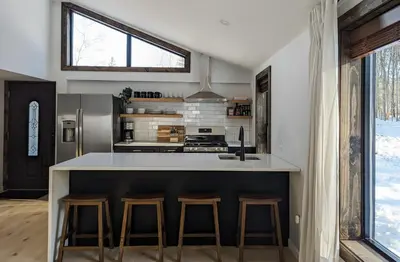a kitchen with a counter and stools in a room at Acorn Lodge - Luxury Cabin, Catskills, Windham Mountain, Hunter Mountain in Cairo