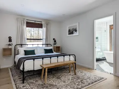 a bedroom with a bed with a table and a rug at Acorn Bungalow - Luxury Cabin, Catskills, Windham Mountain, Hunter Mountain in Cairo
