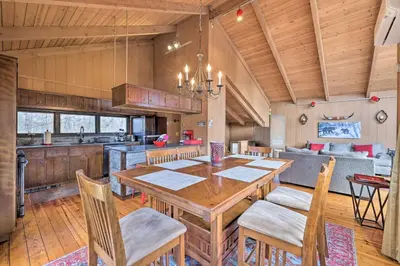 a kitchen and dining room with a wooden table and chairs at Fire Pit and Grill Lakefront Poconos Cottage! in East Stroudsburg