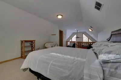 a bedroom with a bed with a white comforter at Large Deck and Resort Amenities Lake Ariel Retreat in Lake Ariel