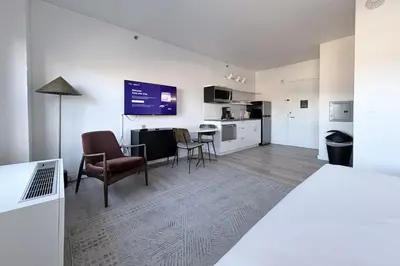 a white room with a bed and a table and chairs at Court Square Hotel Long Island City New York , Belvilla District 6 Formerly Sonder in Long Island City