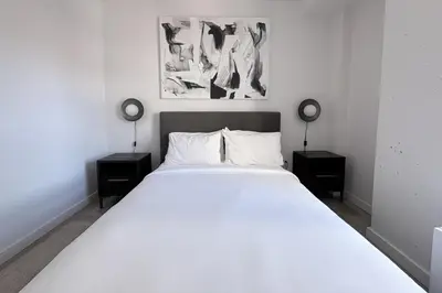a bedroom with a large white bed with two night stands at Court Square Hotel Long Island City New York , Belvilla District 6 Formerly Sonder in Long Island City