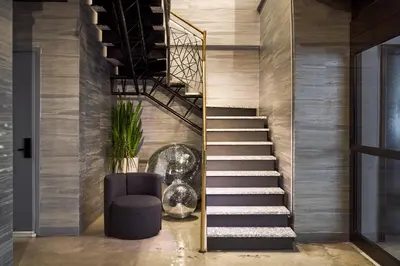 a staircase in a room with a chair and a stair case at The FIDI Hotel in New York
