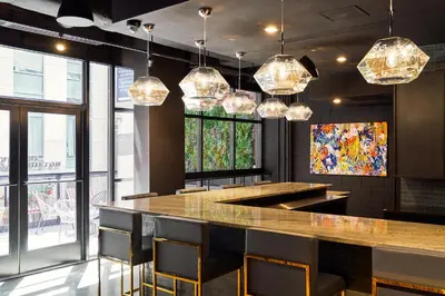 a bar in a restaurant with chairs and lights at The FIDI Hotel in New York