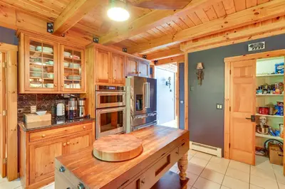 a kitchen with wooden cabinets and a wooden counter top at Luxury Log Cabin with EV Charger and Mtn Views! in Blairstown