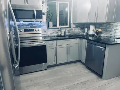 a kitchen with stainless steel appliances and white cabinets at Amazing Poconos House . Sauna/Hot Tub/Private Pool in East Stroudsburg