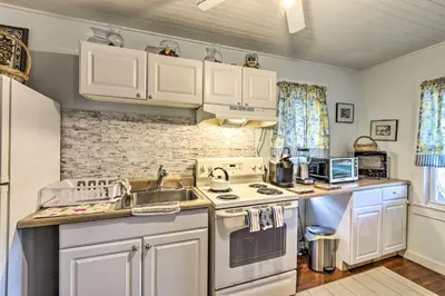 a kitchen with white cabinets and a sink and a stove at Charming Danbury Cottage with Lake Kenosia Access! in Danbury