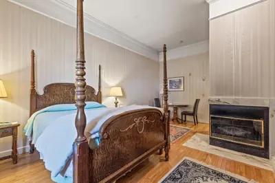 an antique bed in a bedroom with a fireplace at South Shire in Bennington
