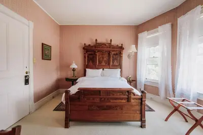 a bedroom with a large bed with a wooden headboard at South Shire in Bennington