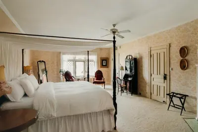 a bedroom with a large white bed and a table at South Shire in Bennington