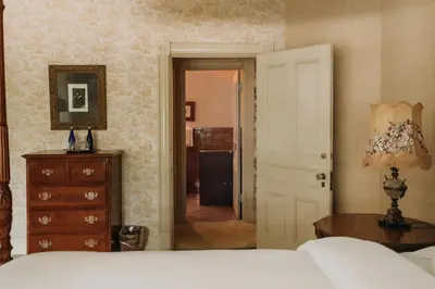 a bedroom with a bed and a dresser and a door at South Shire in Bennington