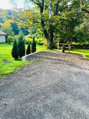 a gravel driveway with a bench in a yard at Homesteading at 55 main in Stamford