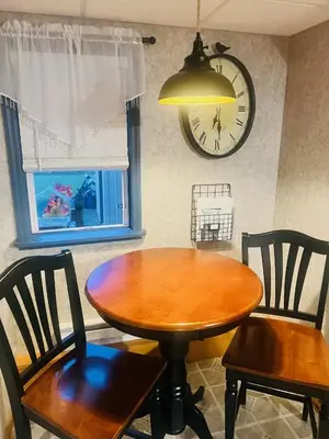 a dining room table with two chairs and a clock on the wall at Homesteading at 55 main in Stamford