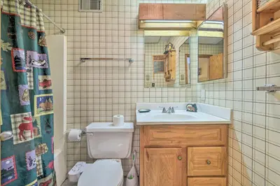 a bathroom with a sink and a toilet and a mirror at Next to Shawnee Mtn Ski Area Inviting Condo! in East Stroudsburg