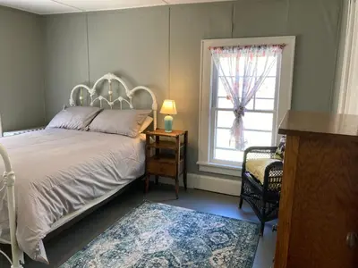 a bedroom with a white bed and a window at Slumberland at the River's Edge in Pond Eddy