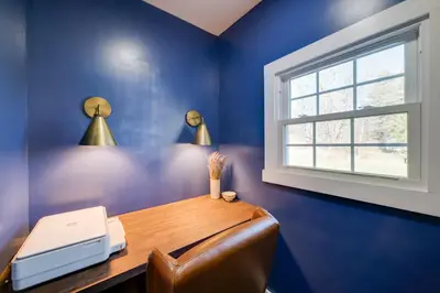 a blue room with a desk with a printer and a window at Less Than 4 Mi to Cooperstown Charming Historic Home! in Fly Creek