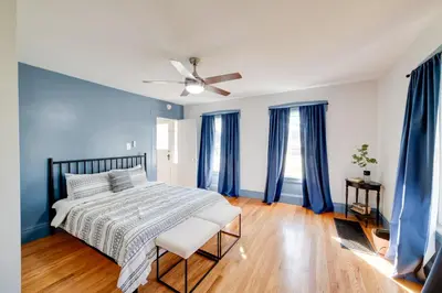 a bedroom with blue walls and a bed with a ceiling fan at Less Than 4 Mi to Cooperstown Charming Historic Home! in Fly Creek