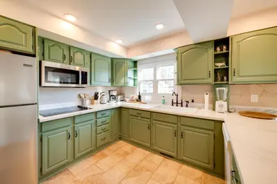 a green kitchen with white appliances and green cabinets at Less Than 4 Mi to Cooperstown Charming Historic Home! in Fly Creek