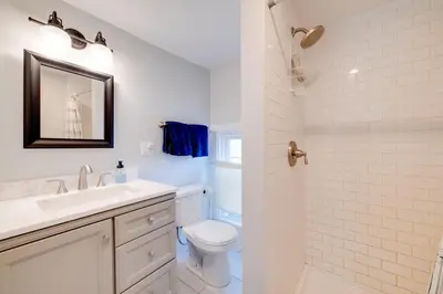 a white bathroom with a sink and a toilet at Less Than 4 Mi to Cooperstown Charming Historic Home! in Fly Creek