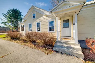 a white house with a white door on a street at Less Than 4 Mi to Cooperstown Charming Historic Home! in Fly Creek