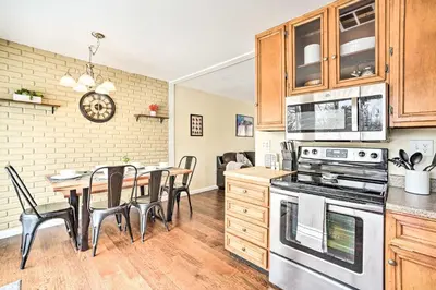 a kitchen with wooden cabinets and a table with chairs at Updated Home in the Heart of Saratoga Springs in Saratoga Springs