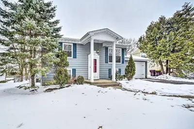 a blue house in the snow with trees at Updated Home in the Heart of Saratoga Springs in Saratoga Springs